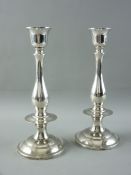 A PAIR OF 925 STERLING SILVER CIRCULAR BASED CANDLEHOLDERS of plain form with shaped columns and