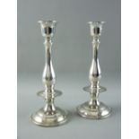 A PAIR OF 925 STERLING SILVER CIRCULAR BASED CANDLEHOLDERS of plain form with shaped columns and