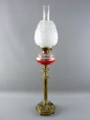 A VICTORIAN OIL LAMP with facet cut clear glass font supported on a brass column stand with a