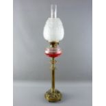 A VICTORIAN OIL LAMP with facet cut clear glass font supported on a brass column stand with a