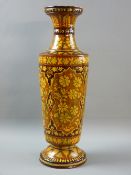 A FLORAL GLAZED TERRACOTTA NARROW NECKED TALL VASE on a circular base, 45 cms high