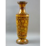 A FLORAL GLAZED TERRACOTTA NARROW NECKED TALL VASE on a circular base, 45 cms high