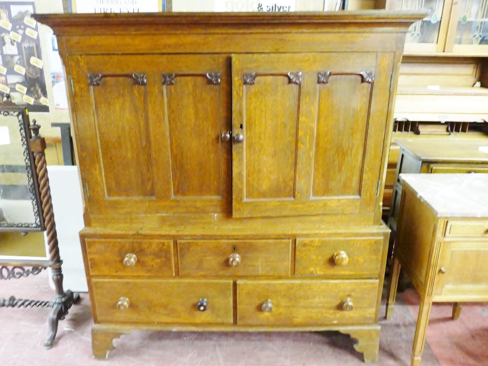 AN EARLY TO MID 19th CENTURY OAK PRESS CUPBOARD, the inverted cornice over two twin panel doors with