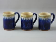 THREE ROYAL DOULTON STONEWARE MUGS with mottled green rim and raised heart decoration on a cobalt