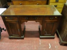 AN EDWARDIAN MAHOGANY KNEEHOLE DESK BASE having three frieze drawers and pedestal cupboard doors