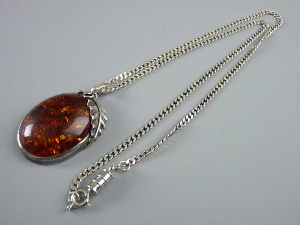 AN OVAL, POSSIBLY RUSSIAN AMBER, PENDANT with leaf adorned frame and a silver curb chain, total 23.5
