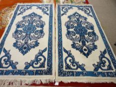 A MATCHING PAIR OF MODERN TIBETAN HANDMADE INDIAN RUGS with blue pattern centres and borders on a