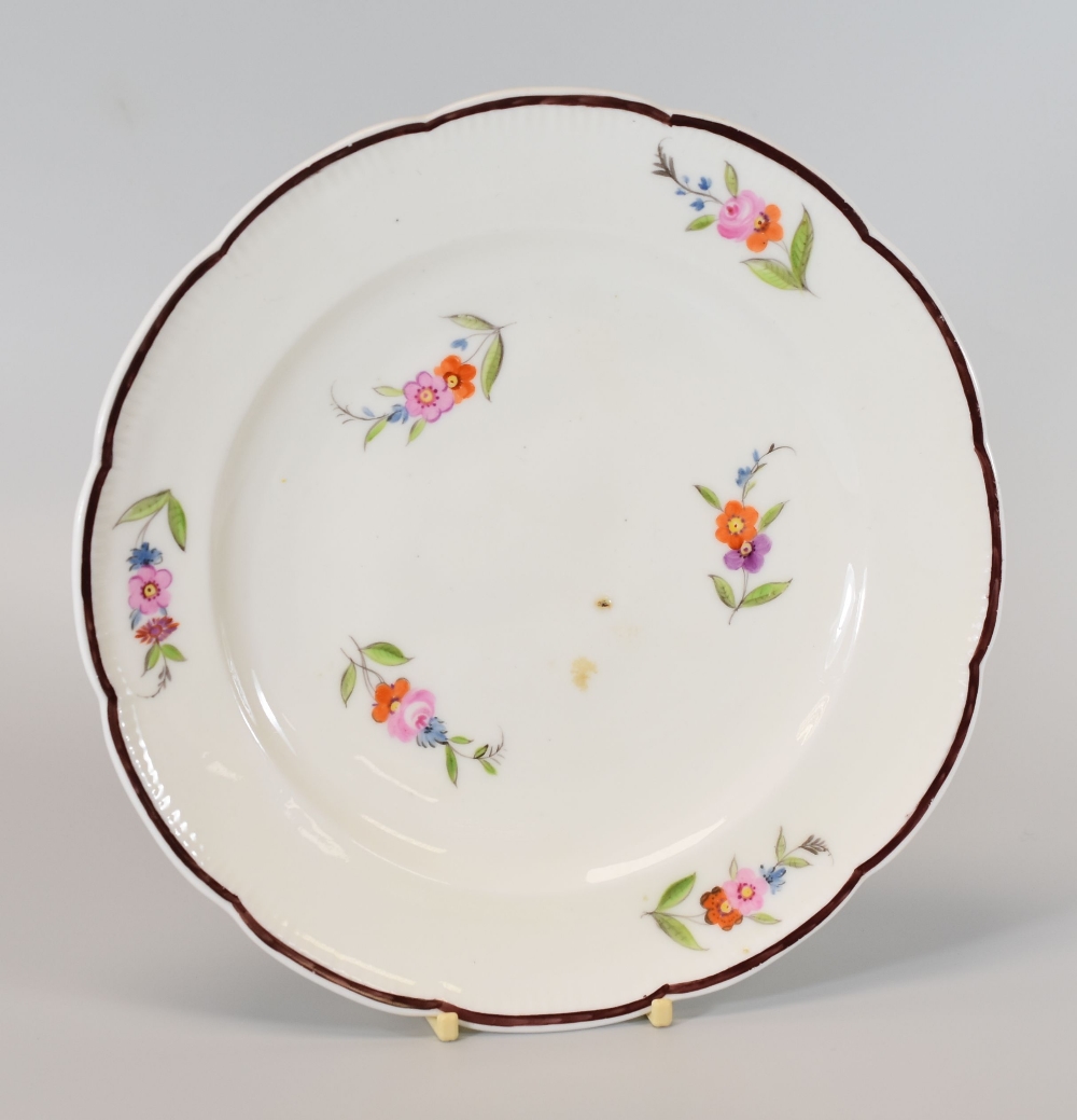 A NANTGARW PORCELAIN PLATE HAVING A CHOCOLATE ENAMELLED RIM, circa 1818, with a lobed and slightly