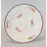 A NANTGARW PORCELAIN PLATE HAVING A CHOCOLATE ENAMELLED RIM, circa 1818, with a lobed and slightly