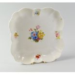 A NANTGARW PORCELAIN SQUARE DISH of lobed form and painted with a centre spray of flowers and four