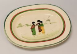 A LLANELLY POTTERY 'DUTCH BOYS' PLATTER with red and green trim, the interior painted with a group