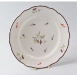 A NANTGARW PORCELAIN PLATE, circa 1818-1820, with a shaped chocolate enamel rim and painted by