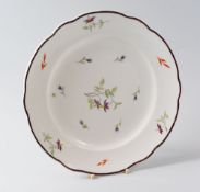 A NANTGARW PORCELAIN PLATE, circa 1818-1820, with a shaped chocolate enamel rim and painted by