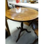 An antique oak tilt-top tripod occasional table