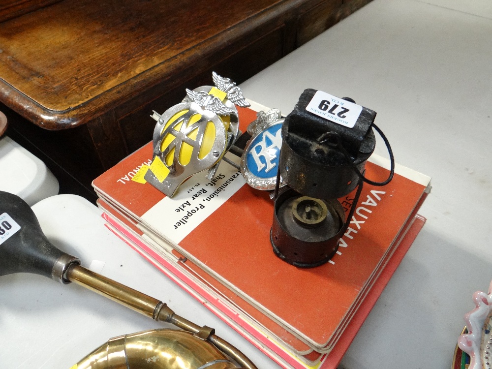 Three breakdown service grill badges, primitive lamp and a collection of motoring service manuals