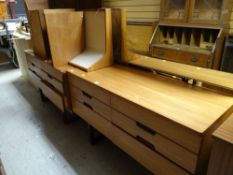 A vintage Uniflex lightwood bedroom suite comprising mirrored dressing table, chest of drawers,