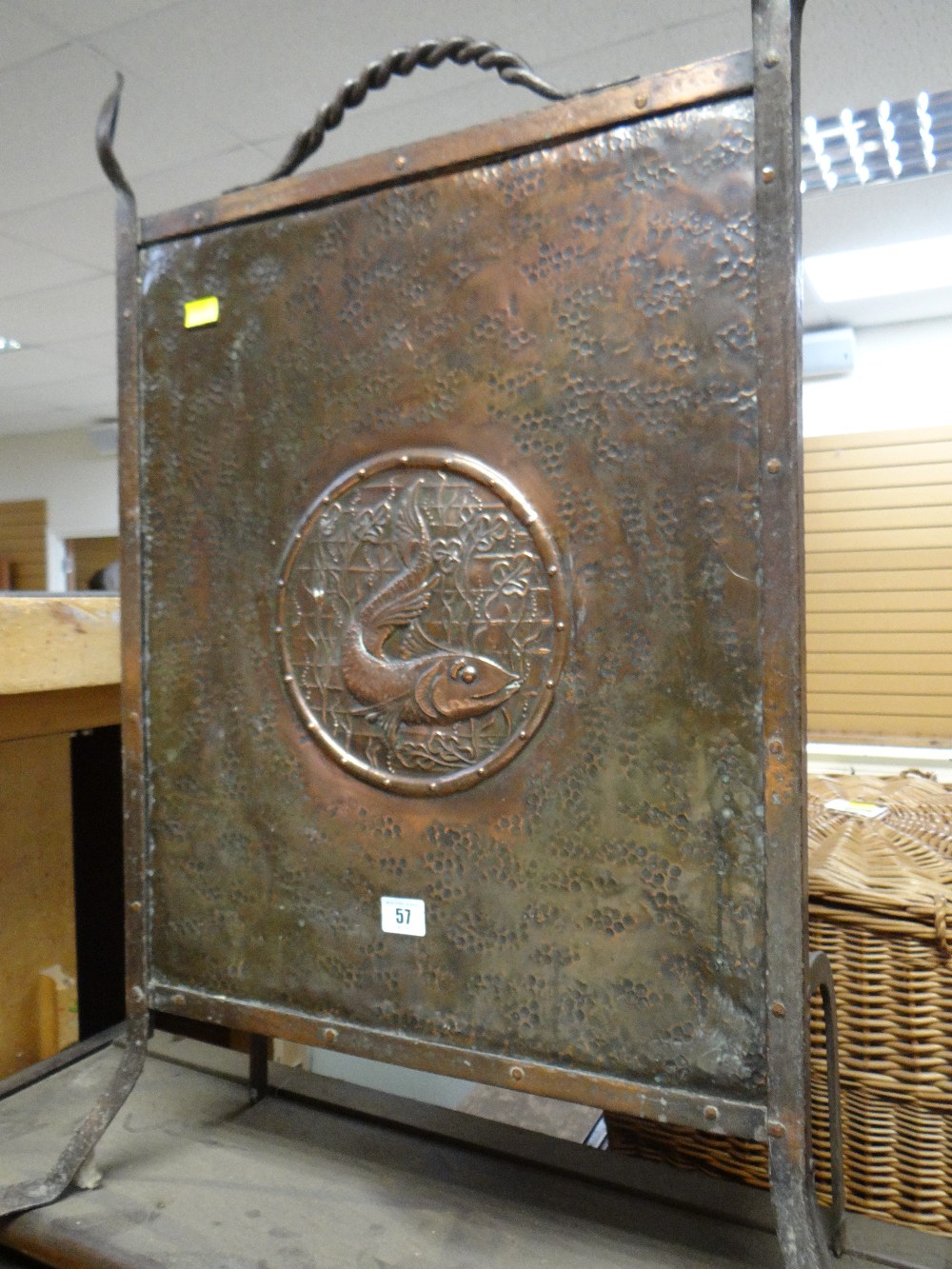 An Arts & Crafts-style beaten copper fire screen with fish cameo