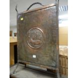 An Arts & Crafts-style beaten copper fire screen with fish cameo