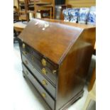 An antique mahogany bureau with four graduated drawers and fitted interior