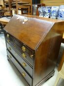 An antique mahogany bureau with four graduated drawers and fitted interior