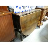 An antique drop leaf gate leg table with turned supports