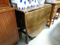 An antique drop leaf gate leg table with turned supports