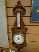 A carved oak encased barometer