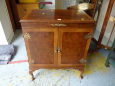 A music cabinet with turn table on cabriole supports with fancy hinges