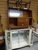 A kitsch vintage china cabinet with floral glass, a sliding door bookcase, two rush stools