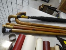 A parcel of walking sticks and a silver collared umbrella