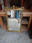 A fancy gilt framed bevelled wall mirror