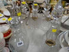 A trio of cut glass decanters, two glass claret jugs and two further decanters together with white