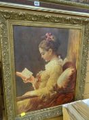 A framed oleograph of a girl reading