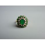 AN EIGHTEEN CARAT GOLD EMERALD & DIAMOND CLUSTER RING of fine quality, the oblong cut emerald (6.4 x