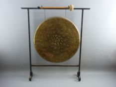 A VINTAGE BRASS & WROUGHT IRON DINNER GONG with beater, 74 cms high, 65 cms wide