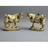 TWO EARLY 19th CENTURY POTTERY COWS IN THE WHIELDON STYLE, mushroom ground colour with deep blue and