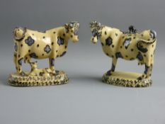 TWO EARLY 19th CENTURY POTTERY COWS IN THE WHIELDON STYLE, mushroom ground colour with deep blue and