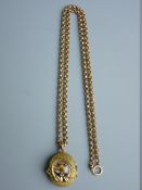 A NINE CARAT GOLD MUFF CHAIN with a yellow metal oval locket, the lid having a horseshoe with enamel