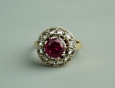 A NINE CARAT GOLD DRESS RING with centre pink stone and twelve small surrounding diamonds, 4.5 grms,