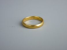 A TWENTY TWO CARAT GOLD NARROW WEDDING BAND, 5.2 grms