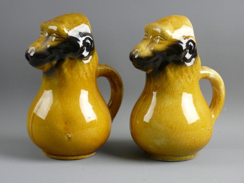 A PAIR OF FRENCH MAJOLICA POTTERY 'BEAMING BABOON' WATER JUGS with the mask faces as spouts, 22