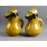 A PAIR OF FRENCH MAJOLICA POTTERY 'BEAMING BABOON' WATER JUGS with the mask faces as spouts, 22