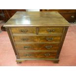 A NEAT REPRODUCTION MAHOGANY CHEST of two short over three long drawers having shaped