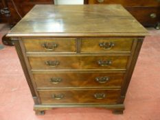 A NEAT REPRODUCTION MAHOGANY CHEST of two short over three long drawers having shaped