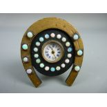 A MINIATURE BEDSIDE CLOCK set with twenty five opals, the enamel dial set with Roman numerals in