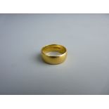 A TWENTY TWO CARAT GOLD WIDE WEDDING BAND, 6.5 grms