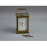 A HEAVY BRASS CARRIAGE CLOCK, late 19th/early 20th Century, white dial with Roman numerals, triple