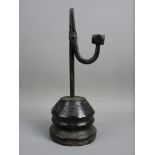 AN ANTIQUE IRON RUSH LIGHT NIP on a turned conical base, the nip arm with faceted weight, the base