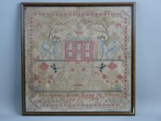 A FRAMED VICTORIAN NEEDLEWORK SAMPLER with central red brick house and goats standing to the