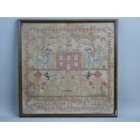 A FRAMED VICTORIAN NEEDLEWORK SAMPLER with central red brick house and goats standing to the